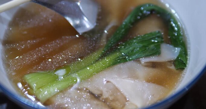 Close up of delicious shrimp wonton soup with green bok choy