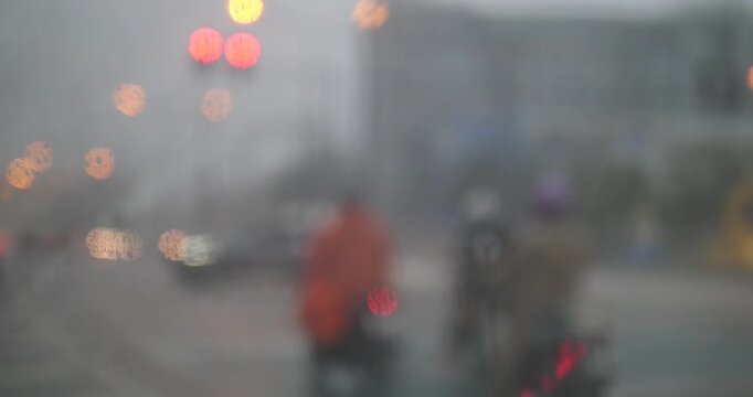 Blurred background of traffic and motorcyclists in heavy rain with bokeh lights