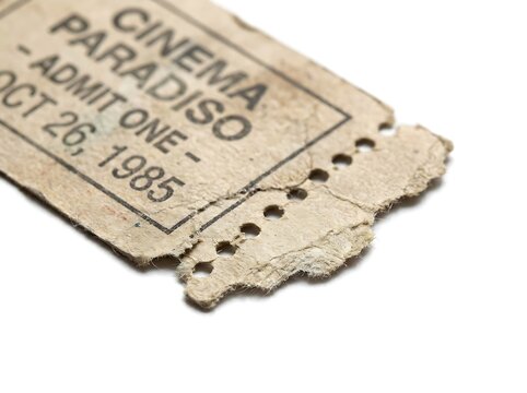 Vintage cinema ticket stub with torn edge on a white background surface
