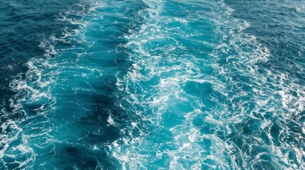 Fototapeta premium Blue ocean water texture with splashing white foam from a boat wake