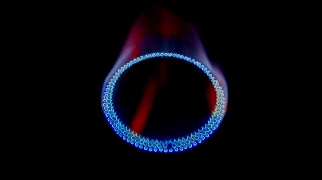 Bright blue and orange gas flame burning from a kitchen stove burner