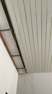 Installed modern slatted false ceiling with gold accent strips in a room