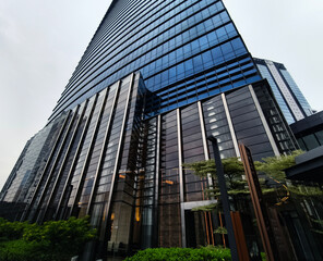 Fototapeta premium Ground level plaza with columned entrance, inviting steps and greenery frame office lobby.