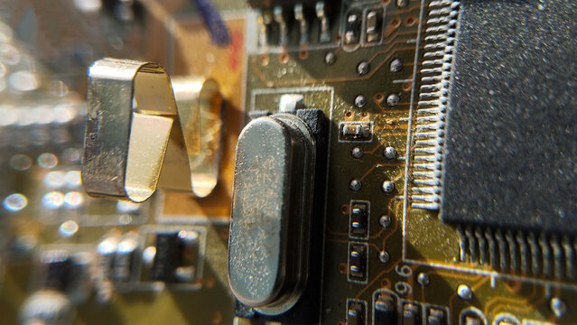 Macro view of integrated electronic components and transistors on an old hardware board in a studio. microchip controller, computer mainboard details, retro circuit texture.