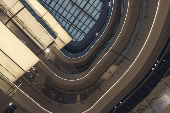 Modern interior architecture of a shopping mall with curved balconies and glass atrium