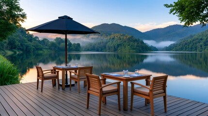 Fototapeta premium Outdoor dining on deck overlooking lake and mountains at dawn