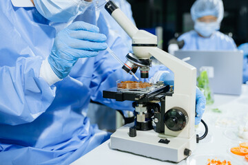 Fototapeta premium Male nutritionist in lab coat analyzing food and writing in notebook. Healthy eating, organic testing