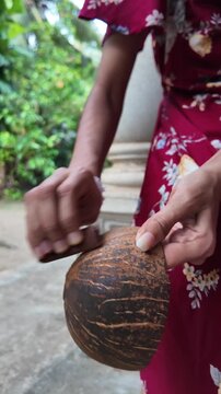Artisan carefully polishing a coconut shell by hand to create a traditional reusable cup, showcasing sustainable craftsmanship and natural materials.