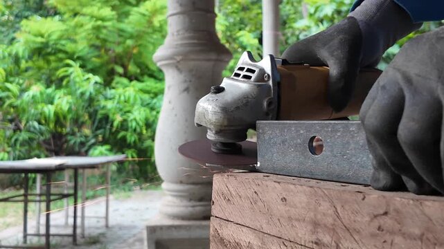  Close-up industrial metalworking scene showing an angle grinder cutting and shaping a steel component with sparks flying from the grinding wheel.
