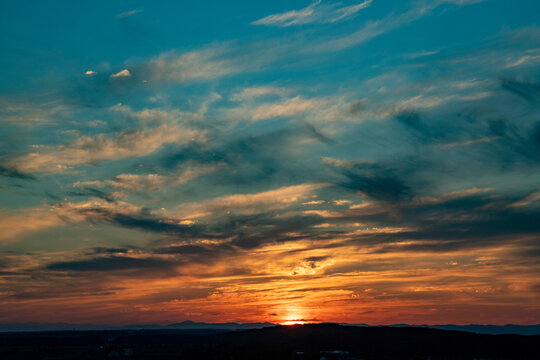 Golden sunset sky with dramatic cloud formations above the distant horizon