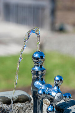 Crystal clear water flowing from park drinking fountain for hydration and refreshment