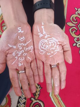 Features Yantra scripts written vertically and diagonally across the palm lines. These usually consist of heart-mantras.