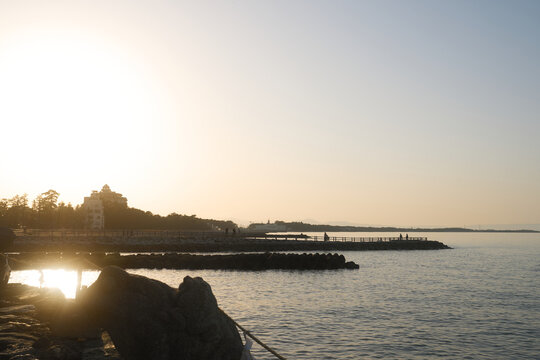 三重県志摩の夕暮れ 防波堤を歩く人々のシルエットと海の風景