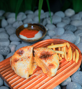 Traditional Turkish cuisine, pide stuffed with minced meat. Middle Eastern snack cuisine on a clay plate, cooked meat pie, cheese pastry pie