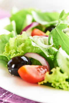 Salad with Olives, Tomatoes and Cucumber on wooden Background. Healthy Snack Idea. Close up