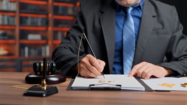Lawyer signs divorce contract paper inside office, experienced lawyer handling legal divorce proceedings before court hearing regarding property division asset split inside marital divorce settlement.