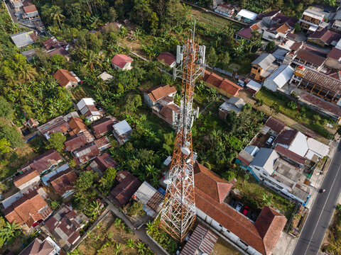 Aerial View of Large Telecommunication Tower Standing Amid a Densely Populated Rural Settlement in Baturaden, Indonesia. 