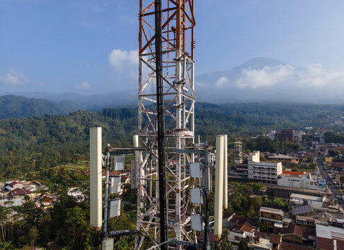 Aerial View of Steel Structures, Radio Masts and Antennas on a Telecommunication Tower in a Rural Countryside with Slamet Mountain in the Distance, Indonesia. 