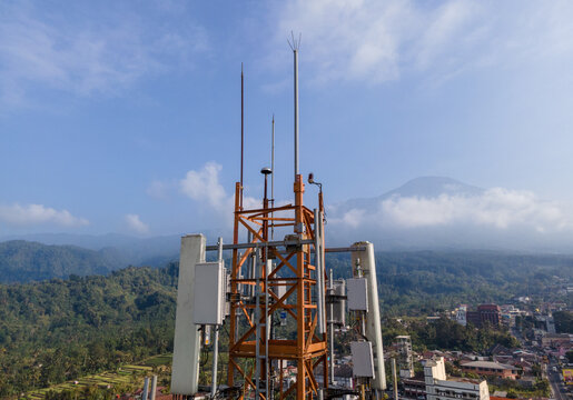 Aerial View of Steel Structures, Radio Masts and Antennas on a Telecommunication Tower in a Rural Countryside with Slamet Mountain in the Distance, Indonesia. 