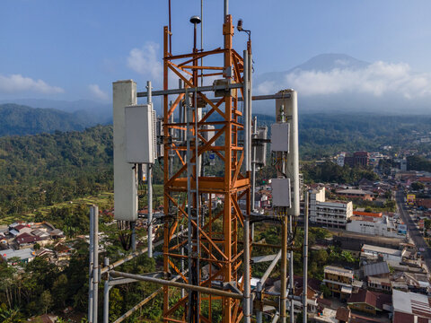 Aerial View of Steel Structures, Radio Masts and Antennas on a Telecommunication Tower in a Rural Countryside with Slamet Mountain in the Distance, Indonesia. 