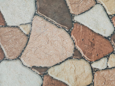 view of natural stone mosaic tiles in warm beige and brown tones, ideal for interior design, architecture, background textures, and decorative construction material visuals.