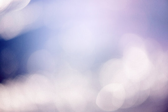 A dreamy blue  purple background with soft bokeh lights, subtle grain, tiny dust particles. The vintage texture gives it a nostalgic, cinematic feel, perfect for adding atmosphere to creative designs.