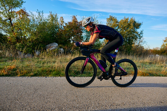 Female Cyclist Riding Aero Road Bike On Countryside Road During Outdoor Training Session
