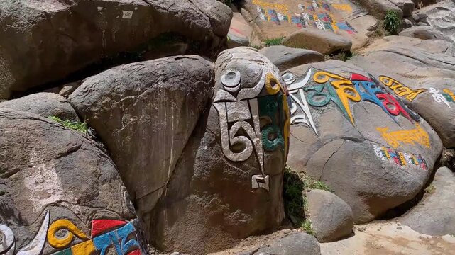 Colorful Om Mani Padme Hum mani stones, Tibetan Buddhist prayer rocks in riverbed, Sichuan China