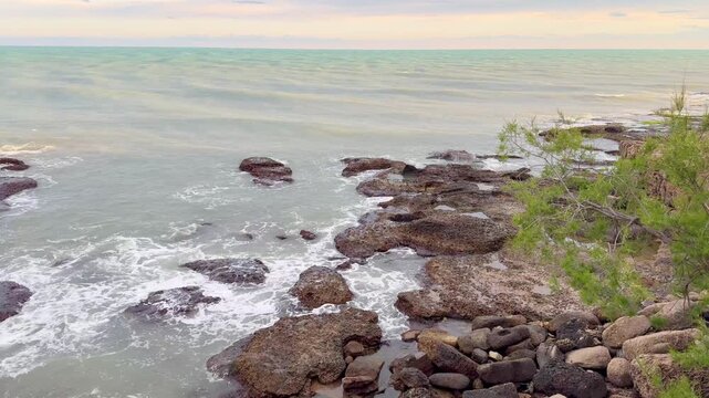 Waves Crashing on Rocky Coastline at Sunset 