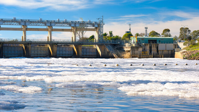 Mulwala weir rises above foam covered Murray River