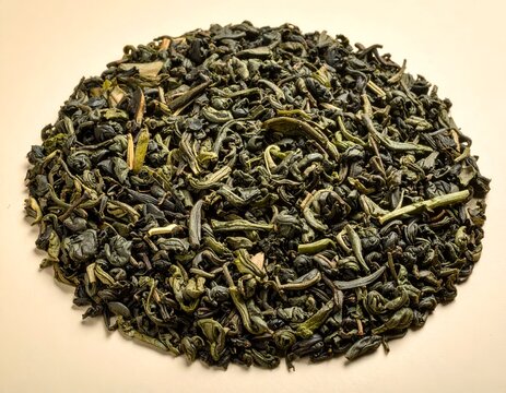 Overhead circular arrangement of dried green tea leaves.