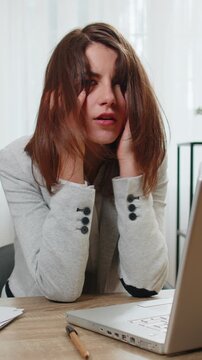 Tired sleepy young businesswoman sitting at home office desk with laptop overworked lazy bored lady worker feel fatigue exhausted of work deprived. Exhausted workaholic freelancer workaholic girl