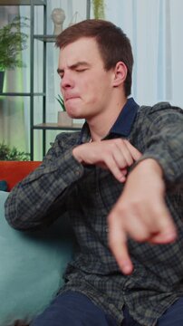 Overjoyed delighted caucasian teenager man showing rock n roll gesture by hands, cool sign, shouting yeah with crazy expression, dancing, emotionally rejoicing in success. Young guy at home apartment