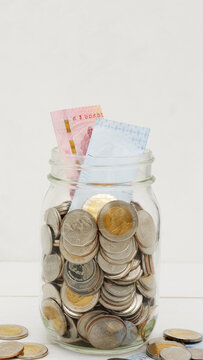 Glass jar full of Thai baht coins. Business and finance concept. Vertical Photography.