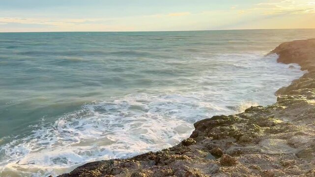 Waves Crashing on Rocky Coastline at Sunset 
