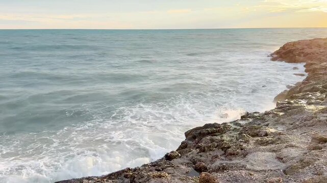 Waves Crashing on Rocky Coastline at Sunset 