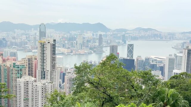 HONG KONG, CHINA &ndash; AUGUST 13, 2026: Panoramic view of Hong Kong skyline and Victoria Harbour seen from the summit of Victoria Peak, with skyscrapers and green hillsides on display.