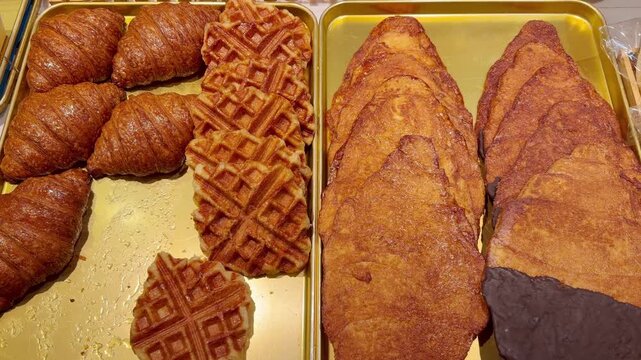 Assorted Croissants and Waffles Displayed in Bakery Pastry Counter 
