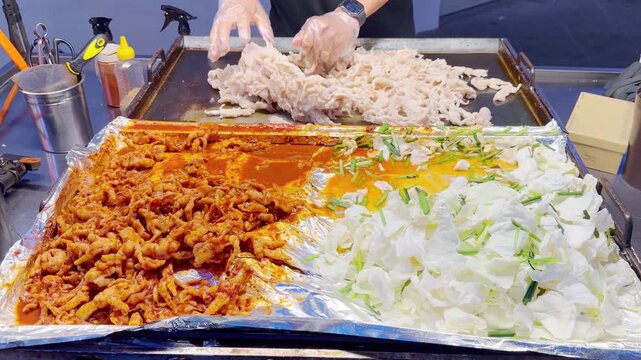 Grilled Chicken Feet with Fresh Cabbage,Dakbal &ndash; Korean Spicy Chicken Feet Frying on Hot Plate with Fresh Cabbage Side &ndash; Popular Street Snack