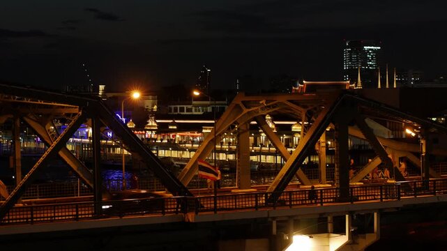 Memorial Bridge Bangkok at Dusk with Pedestrians and Traffic, Thai Flags Waving in Evening Light