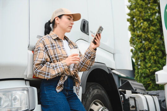 Female truck driver checking smartphone during break