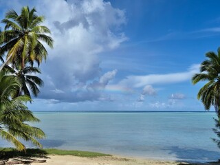 Obraz premium Tropical Lagoon With Palm Trees and Faint Rainbow