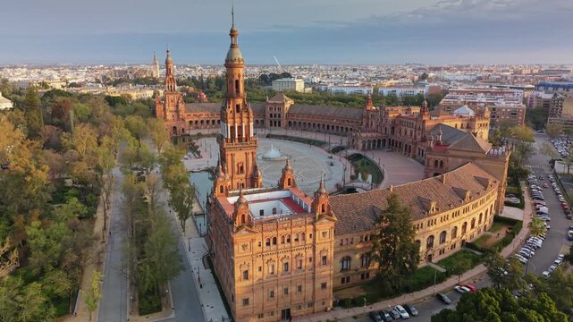 Sunrise light illuminates the iconic Plaza de Espana complex in Seville city center. Morning aerial view showcases Plaza de Espana in Seville, Spain
