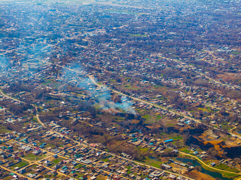 Aerial View of Residential Settlement with Smoke Plumes