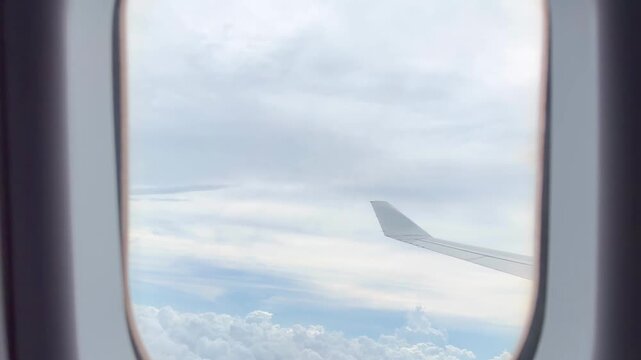 View from Airplane Window Looking Down at Clouds &ndash; Aerial Perspective of Fluffy White Clouds Over Blue Sky