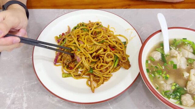 Chinese Restaurant Table with Noodles on Plate and Wonton Soup in Bowl &ndash; Traditional Dumplings and Noodle Dish