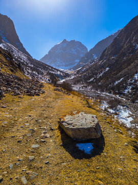 Dramatic Mountain Valley Landscape with Snow and Dirt Path