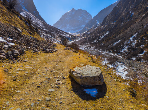 Mountain Valley Landscape with Winding Path and Snow Patches