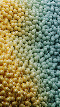 A dense collection of small round yellow and blue spheres piled together to form a textured background