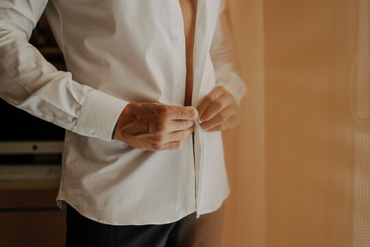 Uomo che chiude i bottoni della camicia